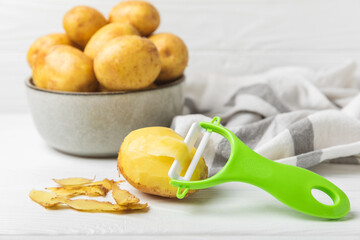 Young potatoes. Raw potatoes and knife on a wooden background.Peel potatoes.Harvesting collection. organic, freshly dug potatoes. Agricultural background. Vegan. Vegetables.Place for text.Copy space
