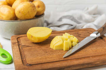 Young potatoes. Raw potatoes and knife on a wooden background.Peel potatoes.Harvesting collection. organic, freshly dug potatoes. Agricultural background. Vegan. Vegetables.Place for text.Copy space