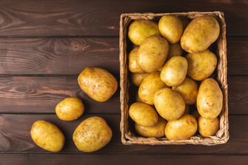 Young potatoes. Fresh potatoes  in wooden crate on a wooden background.Harvesting collection. organic, freshly dug potatoes. Agricultural background. Vegan. Vegetables.Place for text.Copy space
