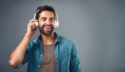 Studio, man and headphone for music, audio media and podcast or ebook on gray background....