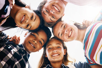Huddle, portrait and happy children in school for teamwork, support or development. Low angle,...