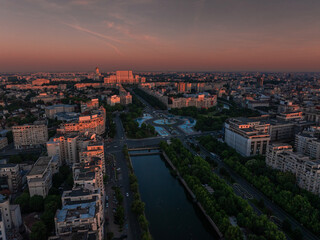 Bucharest aerial photo. Beautiful view of the landmarks of Bucharest from Unirii area (boulevard, fountains and Palace of the Parliament) during a summer sunrise. Travel to Romania.