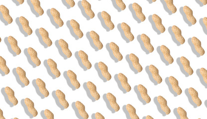 Unpeeled peanuts on white background. Pattern, banner design