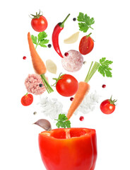 Stuffed pepper recipe. Fresh ingredients falling into bell pepper on white background