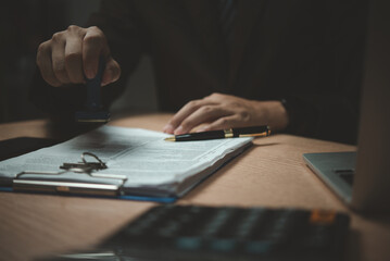 A man is signing a document with a stamp