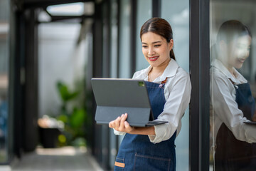 A woman is holding a laptop and smiling