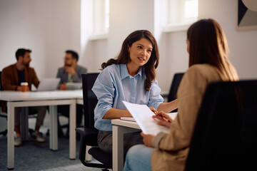 Fototapeta premium Businesswomen communicating while going through paperwork in office.