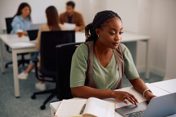 Young black entrepreneur working on her laptop in shared office space.