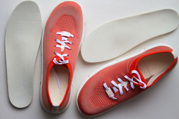 Medical orthopedic insoles with sport shoes isolated on a neutral background. Top view.