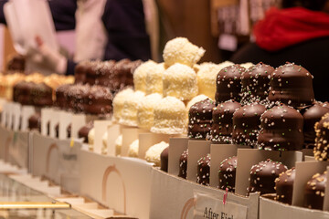 Variedade de trufas gourmet em expositor de confeitaria.