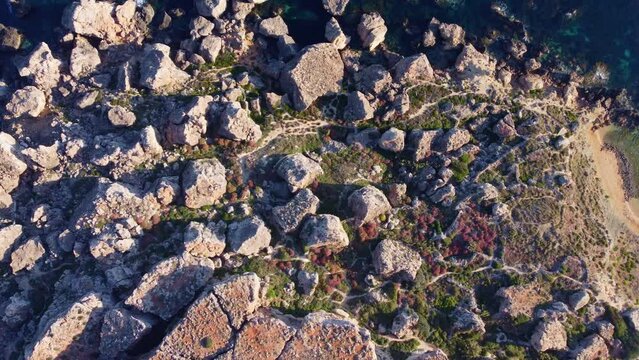 Qarraba Bay flat rock cape Malta, Aerial top down view in the morning sunlight. High quality 4k footage