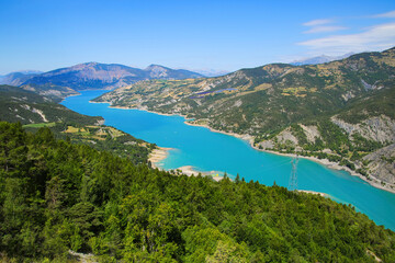 Fototapeta premium Aerial view of the lake of Serre-Ponçon in the French Alps, a dammed artificial reservoir gathering the water of the Durance river