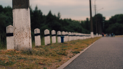 White concrete pillars along the road in the forest