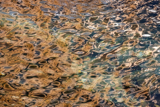 Wavy water patterns reflecting abstract earthly tones