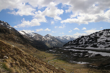 Una preciosa vista de un lago de alta montaña con restos de nieve cielo azul y nubes