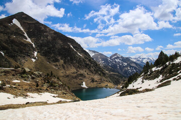 Un lago azul en los Pirineos con cielo azul y nubes