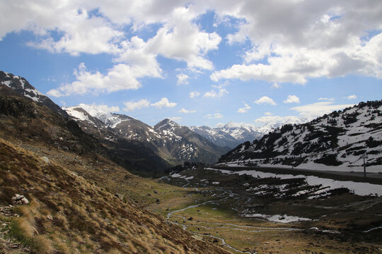 Una preciosa vista de un lago de alta monta&ntilde;a con restos de nieve cielo azul y nubes