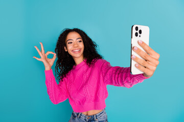 Photo portrait of attractive teen girl selfie photo okey dressed stylish pink clothes isolated on aquamarine color background
