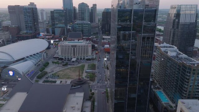 Bird's eye view of downtown Nashville at dusk, featuring iconic buildings and city streets reflected in glass skyscrapers. Capturing the essence of urban life