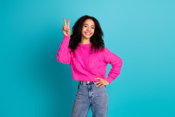 Portrait of nice young girl show v-sign wear pink pullover isolated on turquoise color background