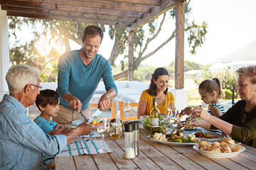 Happy family, eating and lunch with food on patio outdoor with conversation, bonding or healthy meal in summer. Parents, grandparents and kids at dining table in backyard of home with love or talking
