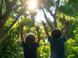 Two children with raised hands stand in a sunlit forest, surrounded by lush green foliage.