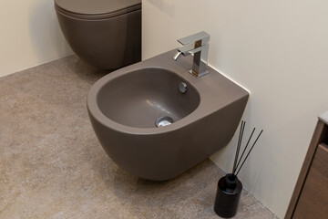 Dark toilet and sink in a minimalist style.
