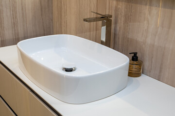 Stylish white sink with a modern faucet in the interior of the bathroom.