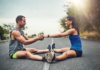 Stretching legs, floor and couple in road with fitness for running challenge, marathon training or cardio in morning. Runner, warm up and athlete man with woman for workout, exercise or getting ready