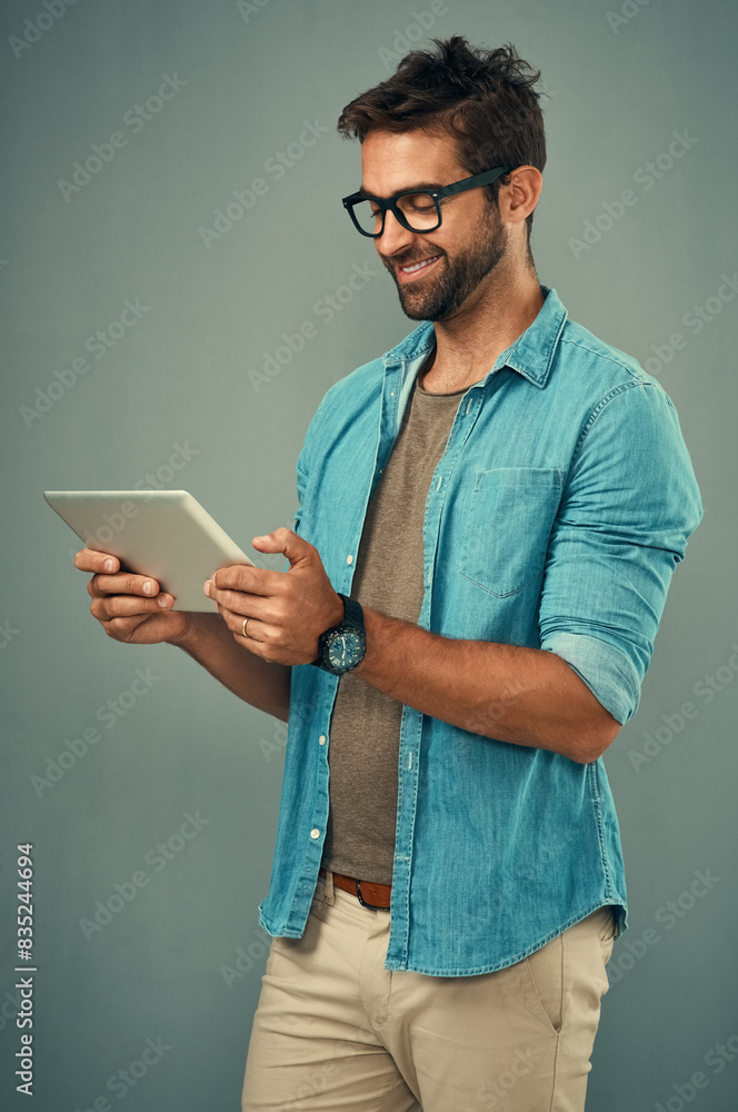 Poster Man, studio and reading with tablet and glasses, career with software programming in London. Male creative, ebook and gray background with happiness for digital job, mobile app or website development