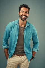 Obraz premium Casual, fashion and smile with portrait of man in studio on gray background for relaxed clothing style. Confident, denim and happy with natural person in clothes outfit to model jacket or wardrobe