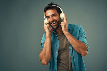 Smile, man and headphone for music in studio, audio media and podcast or ebook on gray background....