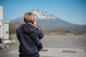 Person photographing a mountain in outdoor setting. Concept of travel and nature photography