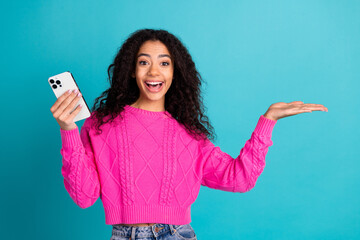 Photo portrait of lovely teen lady amazed hold device thumb up empty space dressed stylish pink...