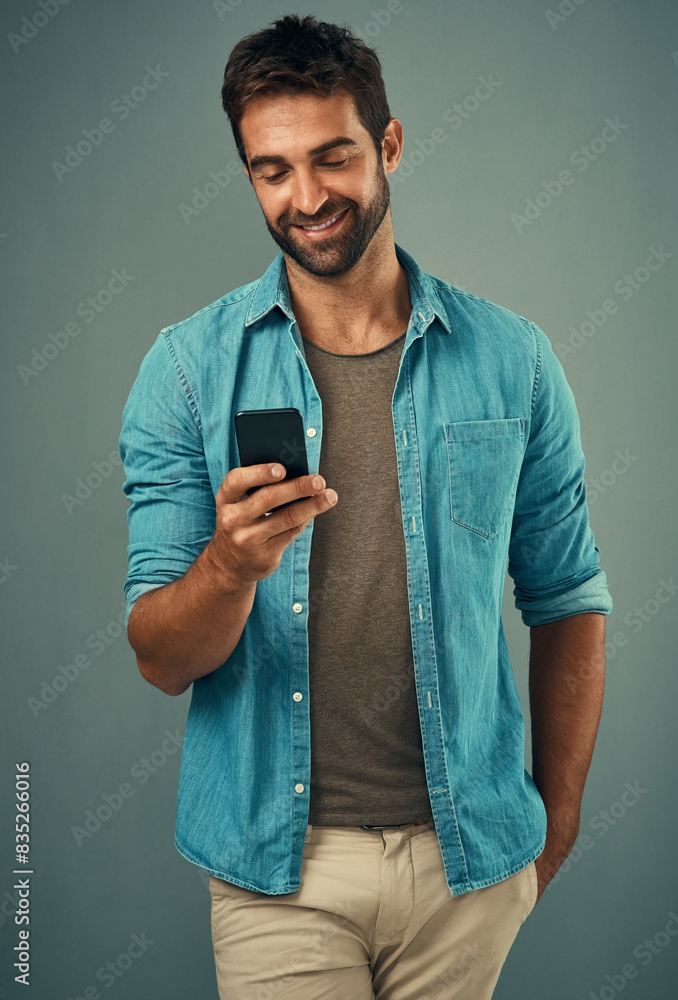 Poster cellphone, smile and read with man in studio, communication and social media on gray background. int
