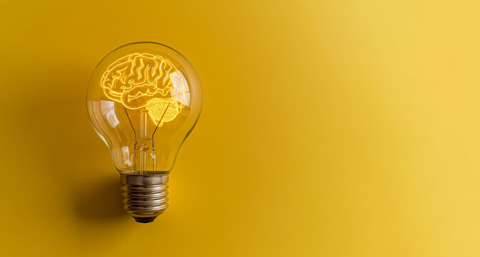 Light bulb with brain-shaped filament glowing against a yellow background, symbolizing creativity and innovation.