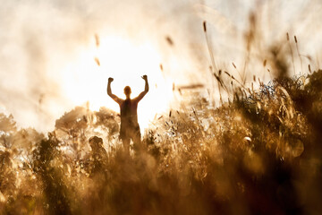 Field, celebration and silhouette of person with sunset for fitness goal, training achievement and...