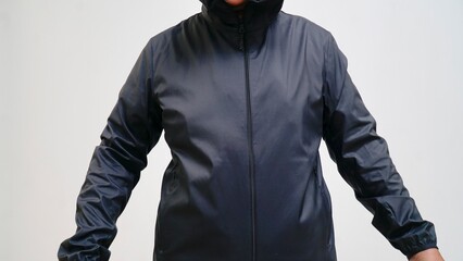 A model wearing a black windbreaker jacket with the hood up © jatupron