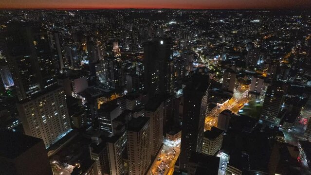 Imagem aerea de Curitiba, Paran&aacute;, durante a noite. V&iacute;deo de drone destaca as luzes da cidade a noite