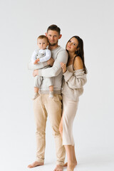 Mother and father hold a one-year-old son of a child in their arms. Happy family with a baby