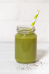 green smoothie with chia seeds - healthy superfood on white background, vertical