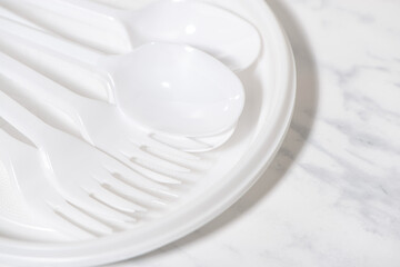 plastic disposable tableware on white background, top view