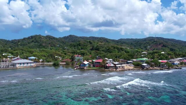 4k resolution drone video of buildings and homes on the coastline of roatan honduras in the caribbean
