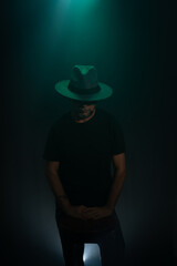 Mysterious, bearded man wearing a hat posing for the camera. Studio portrait.