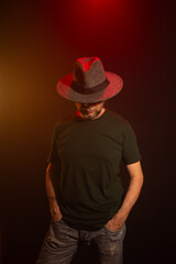 Mysterious man wearing hat standing posing for photo. Studio portrait.