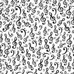 Hand-drawn treble and bass clef musical symbols arranged in vector seamless pattern. Surface art texture in black and white for use in fabric or graphic design or printing on various surfaces.