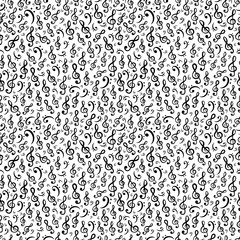 Hand-drawn treble and bass clef musical symbols arranged in seamless pattern. Surface art texture in black and white for use in fabric or graphic design or printing on various surfaces.