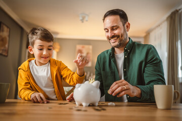 Father and son save money coins together at piggy bank at home