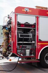 Red firetruck firemen helping people in staged training