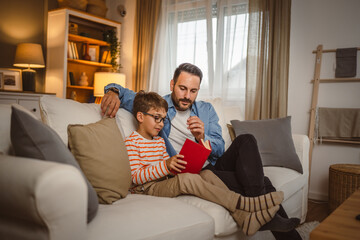 Father and son read a book and have fun while spend time together